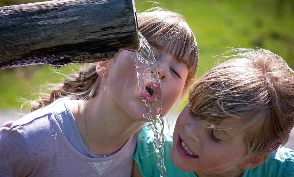 Kinder trinken Hahnenwasser